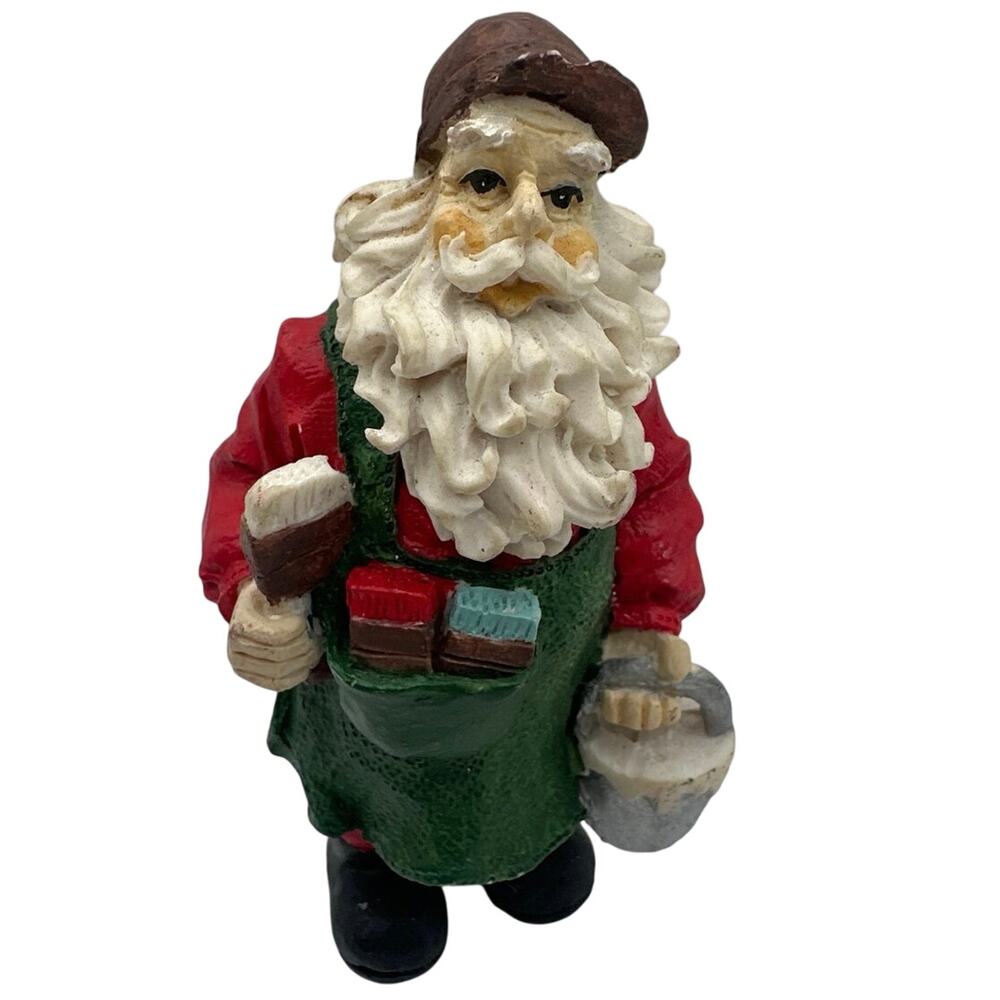 Vintage Santa Clause figurine in brown cap and green apron working/Painting.